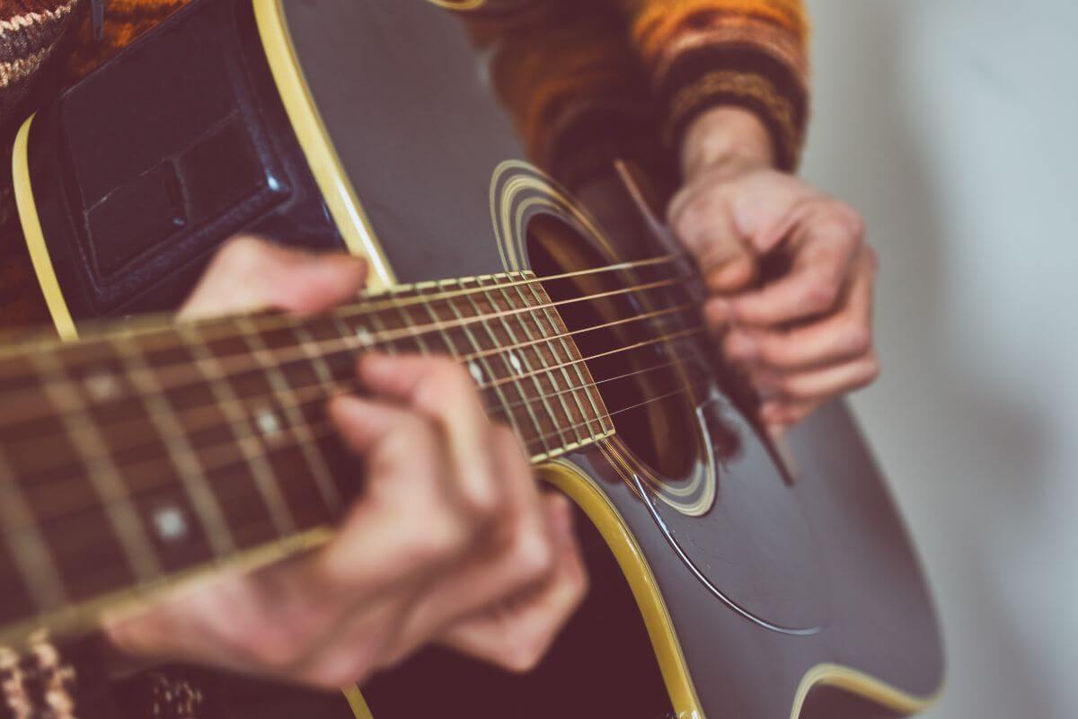 A close up of a person playing an acoustic guitar in Montana.