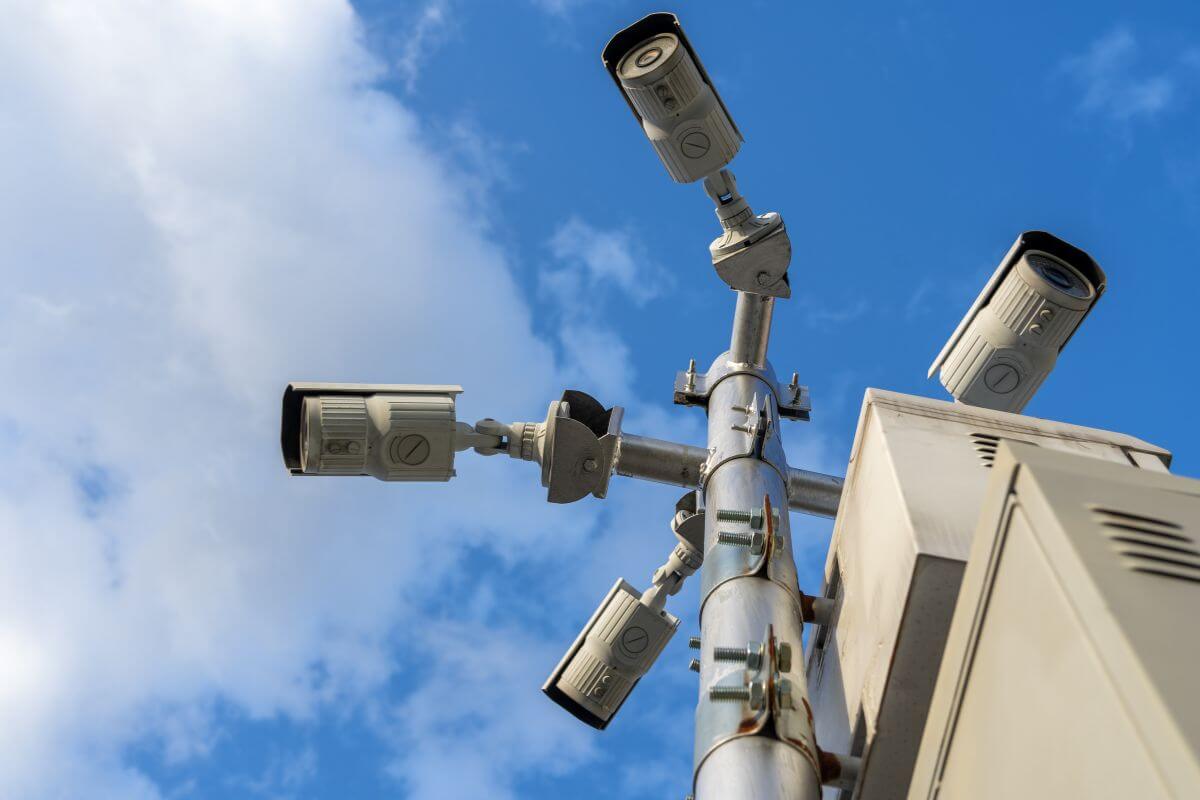 Montana webcams on a pole capturing scenic views against a blue sky.