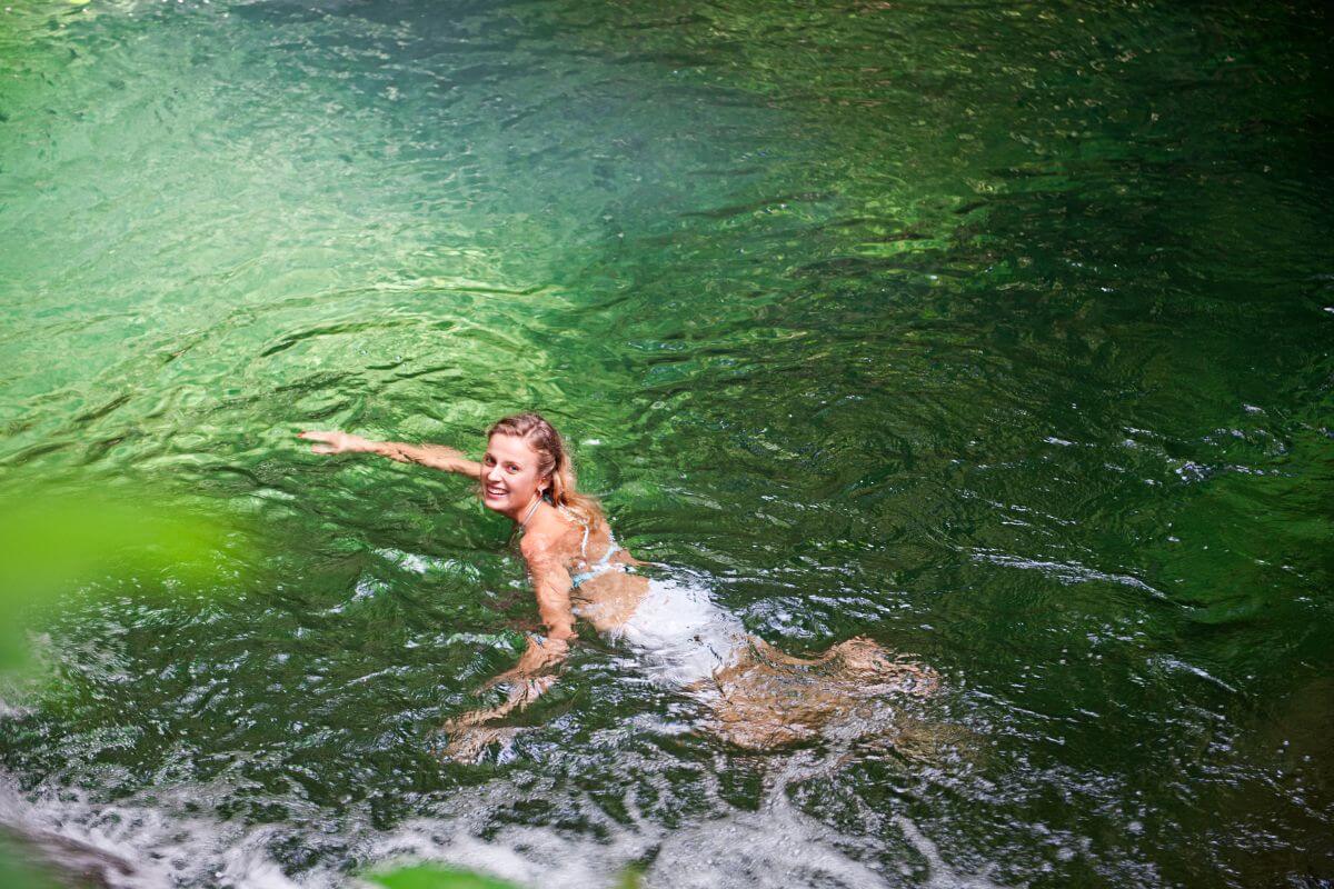 A woman swims in the emerald-green waters of Lava Lake