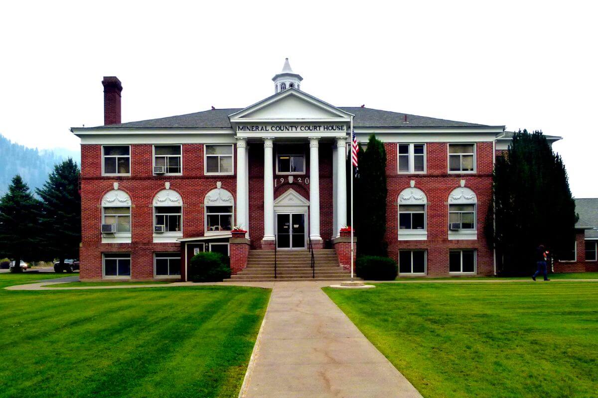 A red brick building with columns and a grassy lawn