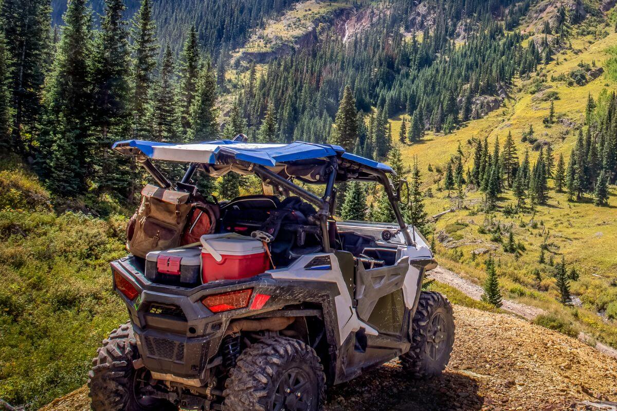 A rugged all-terrain vehicle packed with gear for adventure poised on a rocky trail in Montana.