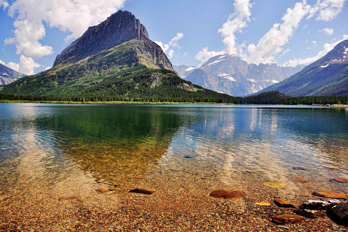 Swiftcurrent Lake in Montana surrounded by mountains and boasting crystal-clear water.