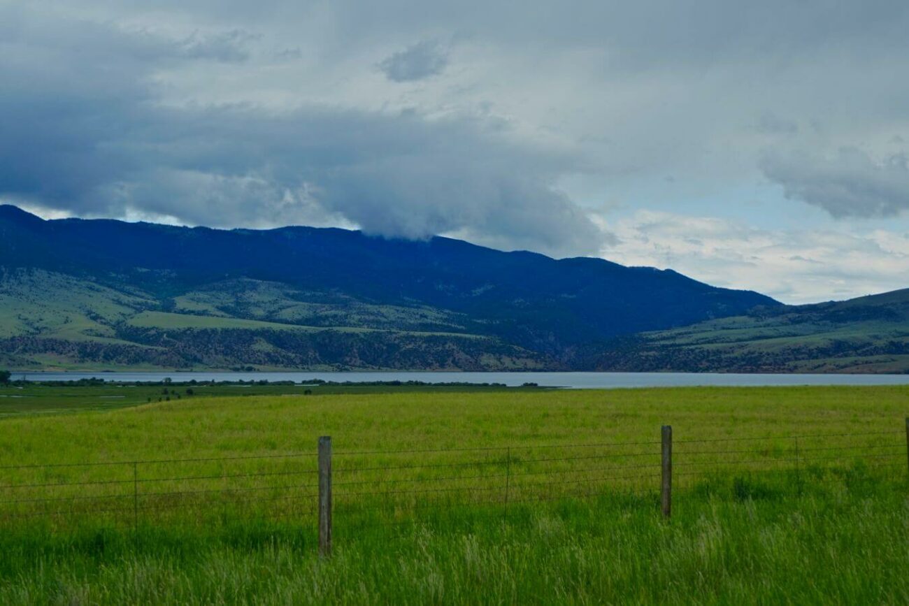Ennis Lake, a top boating location in Montana, amid rolling hills under a cloudy sky