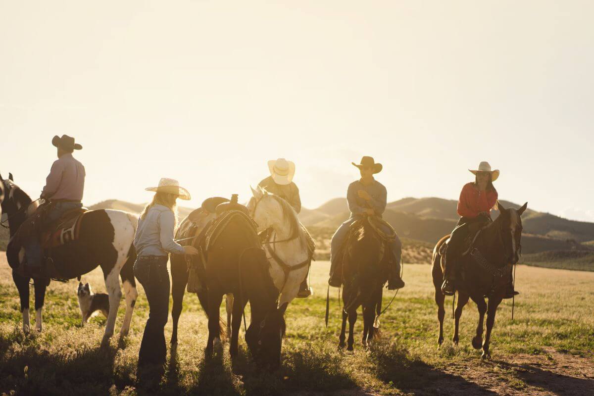 A group of horseback riders travel across Montana's plains during the golden hour.






