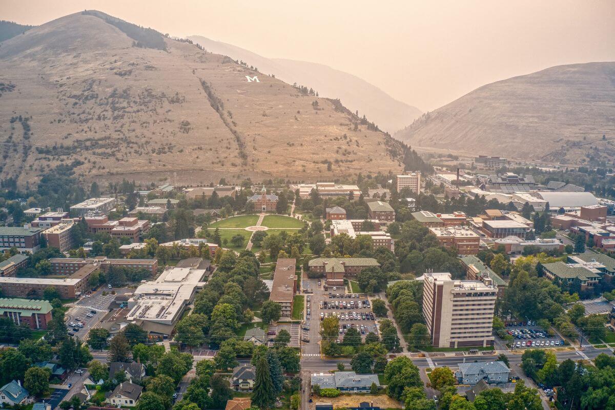An aerial view of a college campus with mountains in the background in Montana.