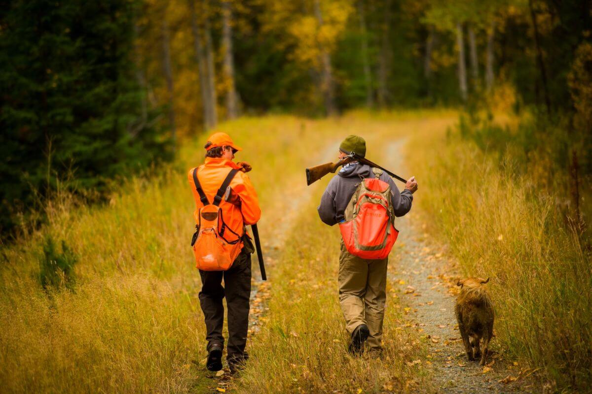A couple of hunters, accompanied by a hunting dog, are guided by Linehan Outfitting on their wolf hunting trip.