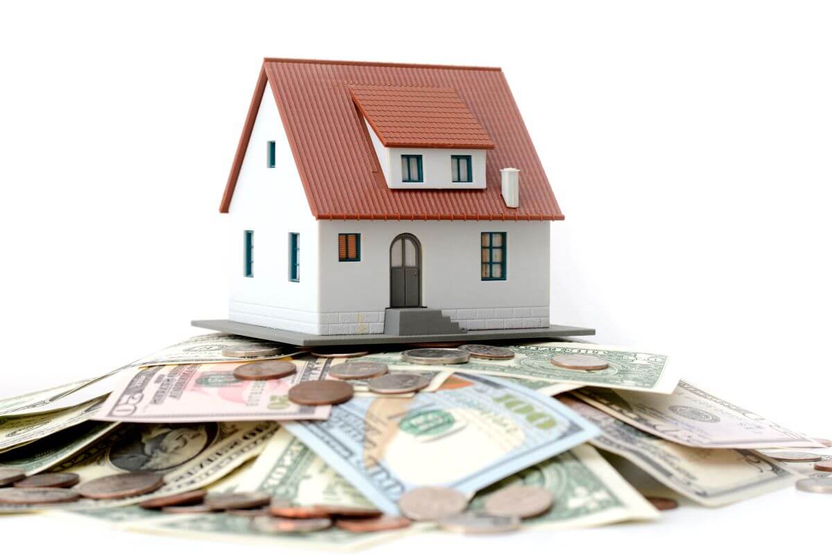 A house model on top of a pile of money