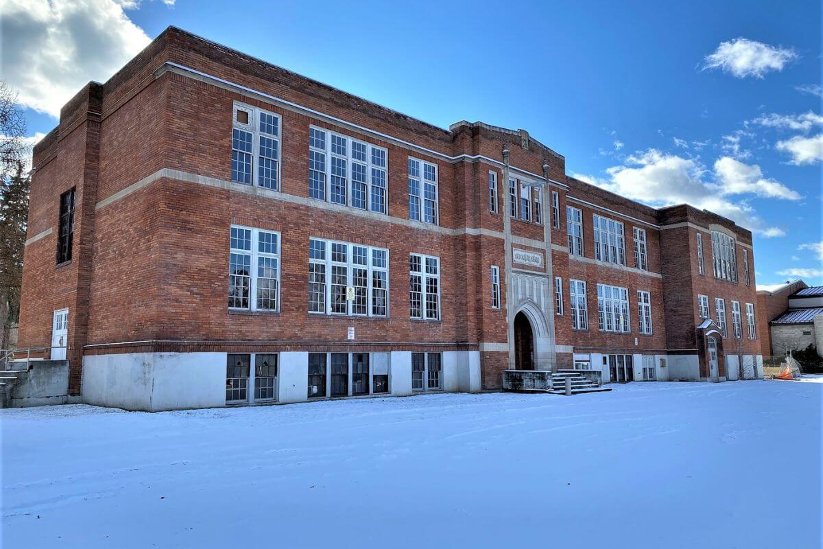 An old brick building with snow on the ground
