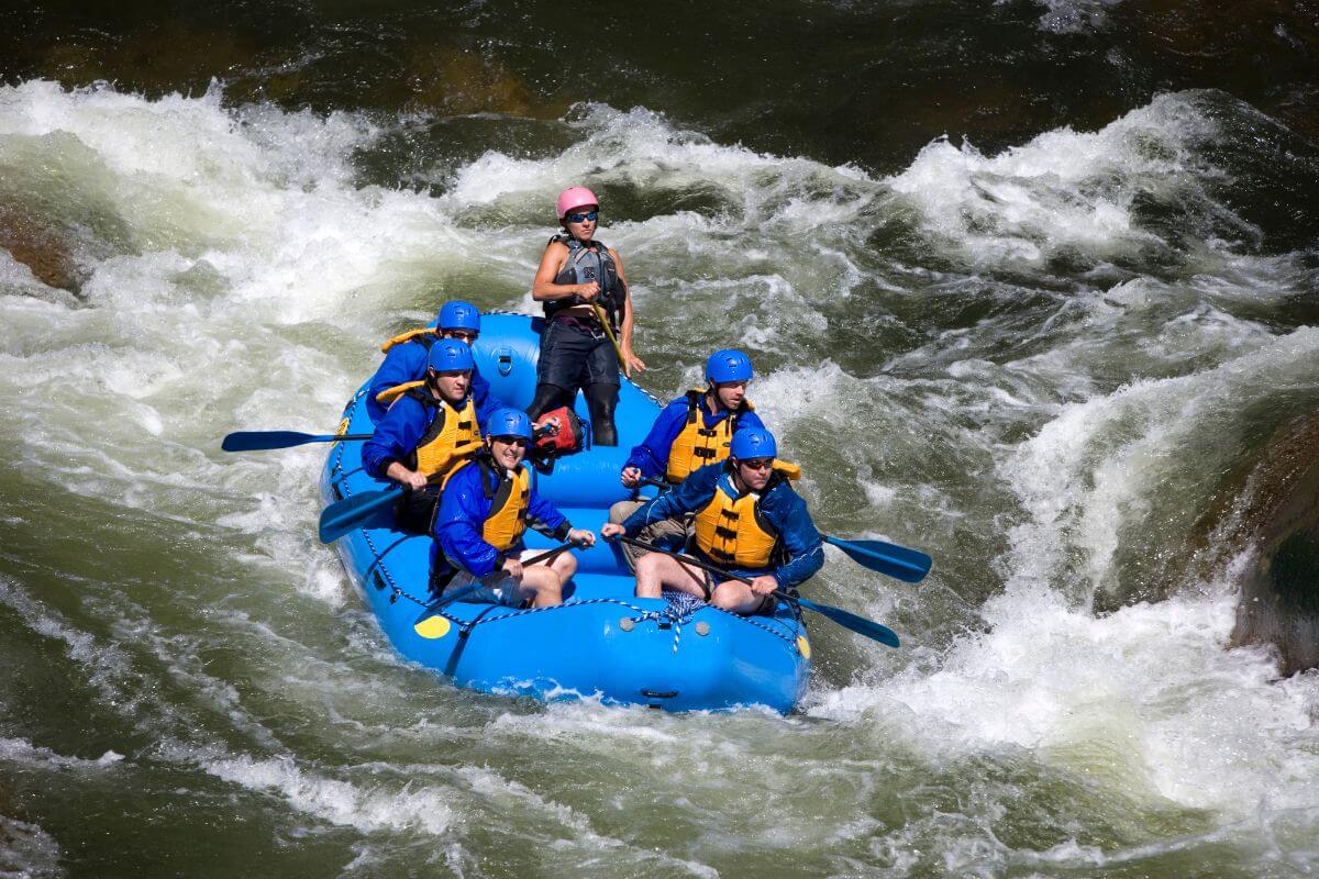 A group white water rafting through the rushing river rapids near Needles Falls in Montana.