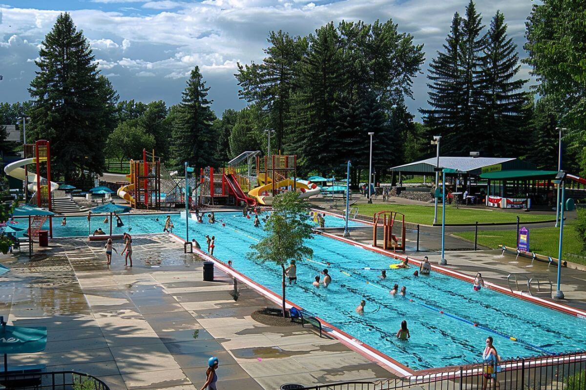Guests enjoy a large pool with water slides and additional structures for engaging water activities at Woodland Water Park in Montana.




