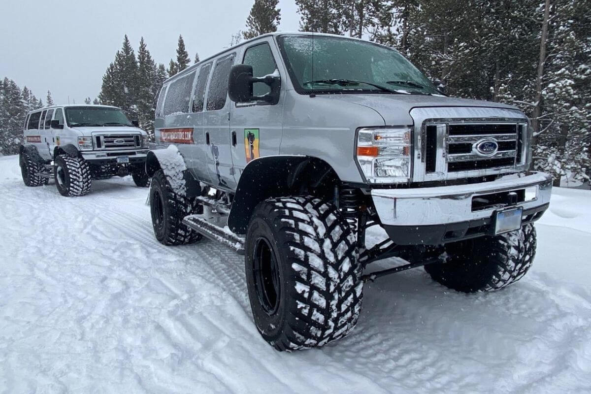 All-terrain Jeeps from Yellowstone Vacations, equipped with massive snow tires, ready to tour Montana's snowy landscapes.