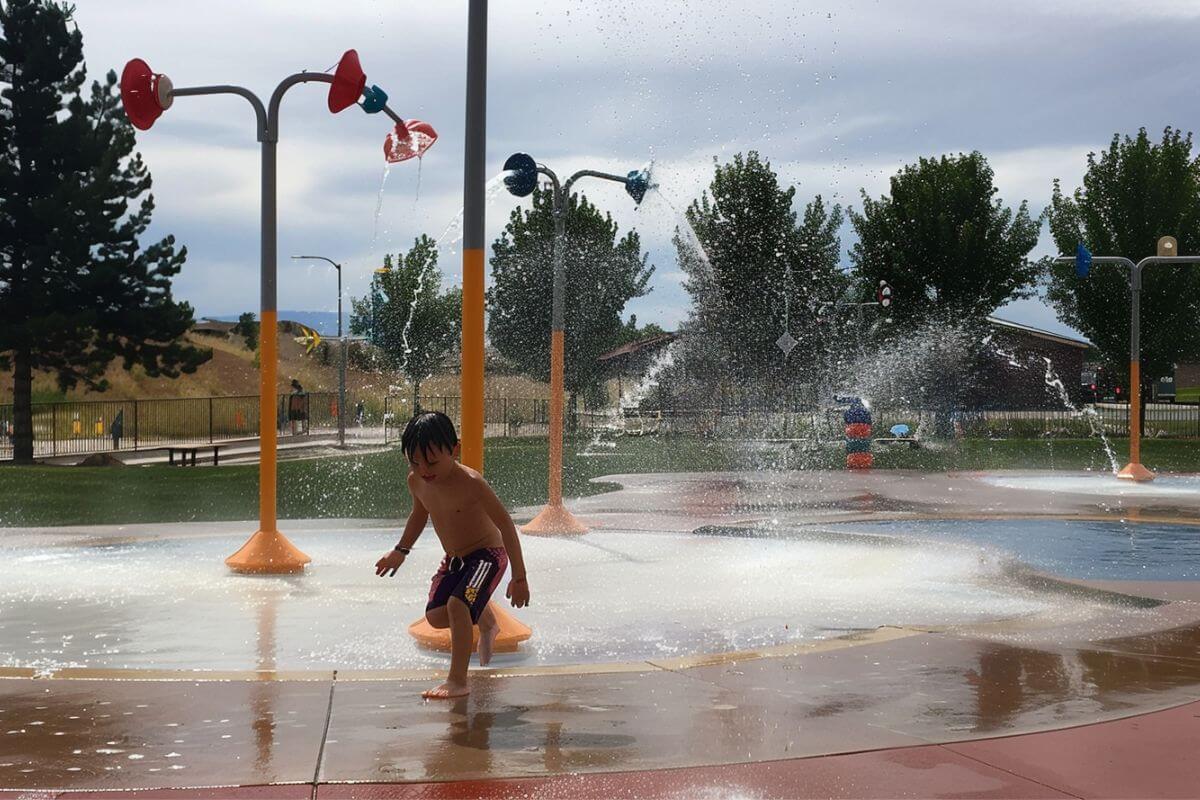 A young boy runs excitedly through the sprayground at Montana's Castle Rock Splash Park.