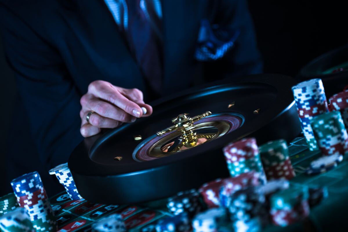 A man in a suit is playing roulette at a casino table in one of the luxurious Montana casinos with hotels.