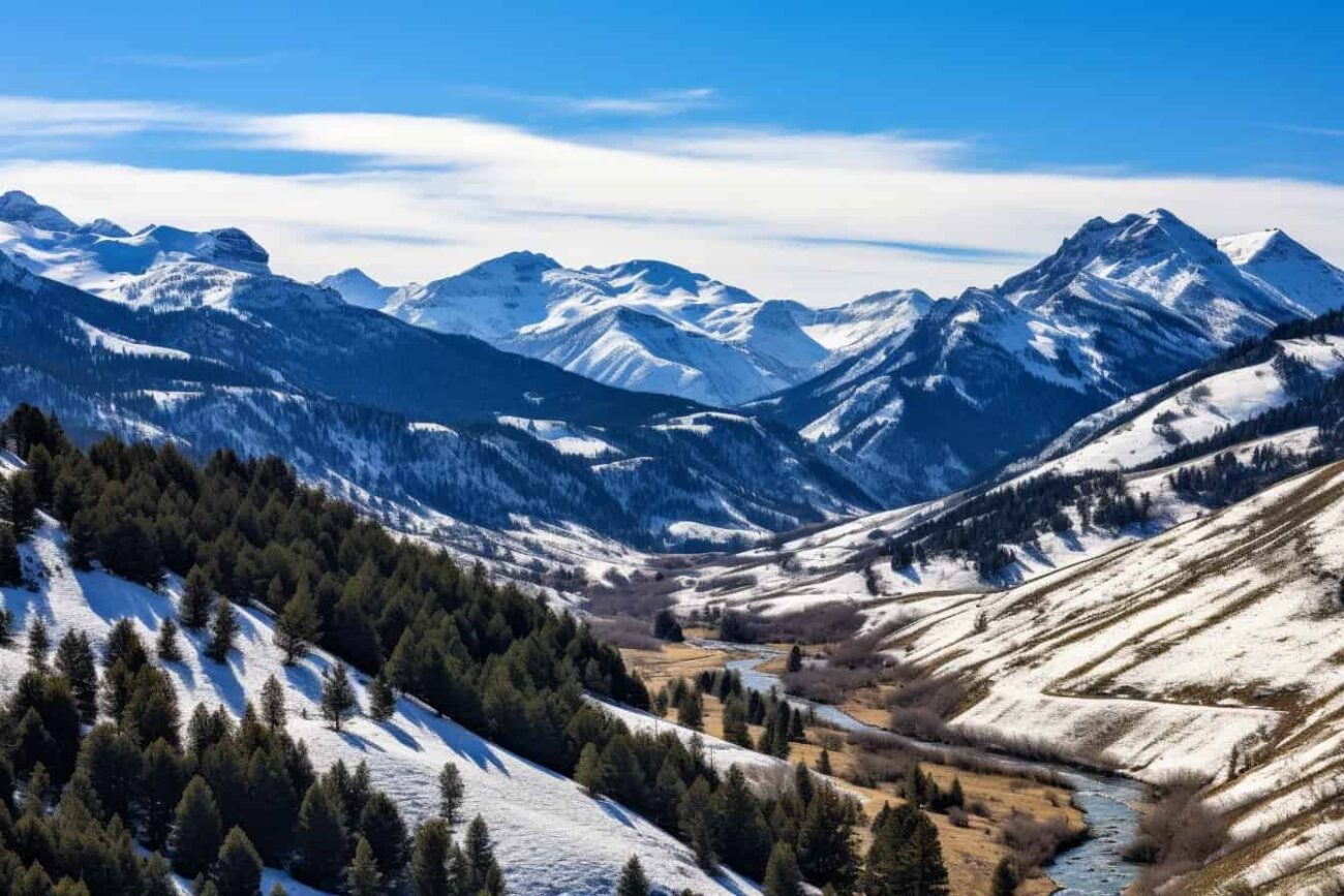 A valley with snow covered mountains and a river in Montana.